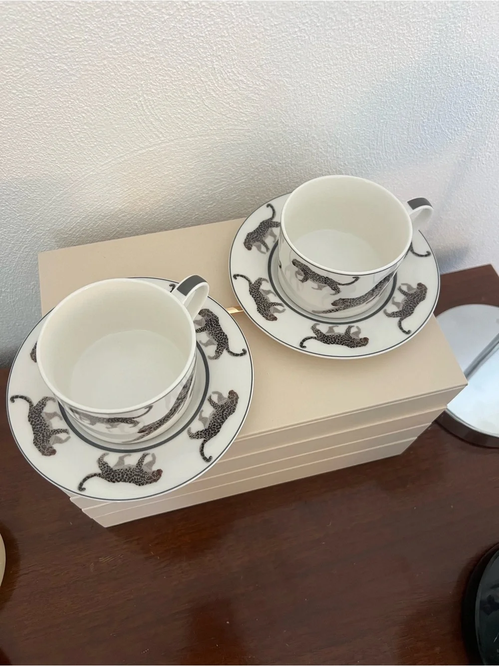 Cup and saucer set with black leopard print on white background